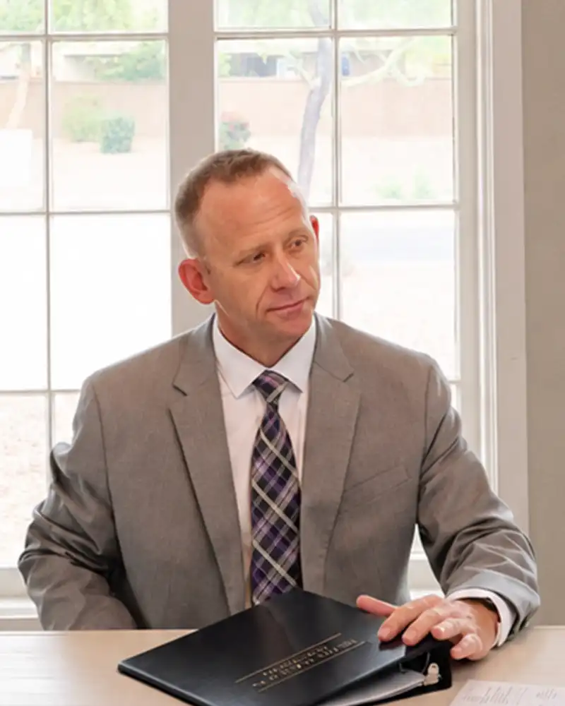 Attorney Jeffrey L. Grayson seated at a conference table with a client binder